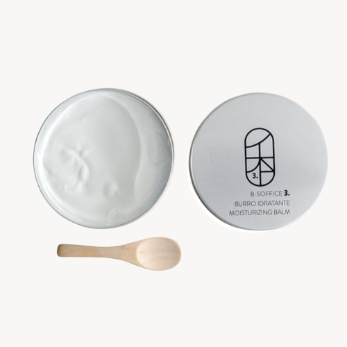 Moisturizing balm with a wooden spoon on a white background